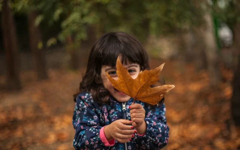 Kids playing in fall leaves
